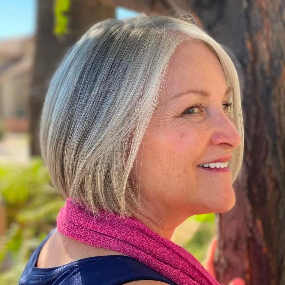 Chin-length silver and platinum blonde bob on smiling mature client at Salon Lola in Gilbert, Arizona